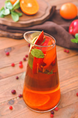 Jug of tasty cold tea on wooden table
