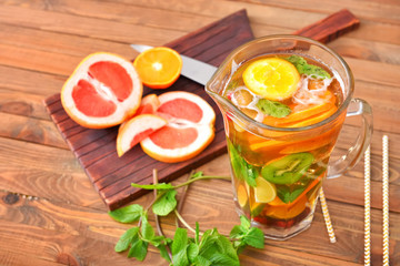 Jug of tasty cold tea on wooden table