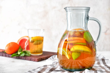 Jug of tasty cold tea on white background