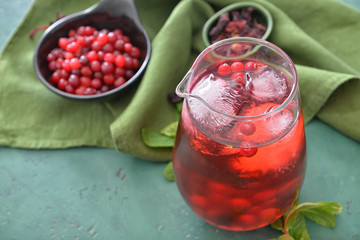 Jug of tasty cold tea on color background