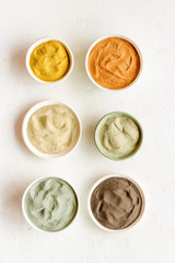 Blue, yellow, white. red, black cosmetic clay background on white table top-down pattern