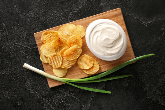 Tasty Sour Cream, Green Onion And Potato Chips On Table