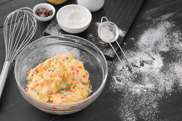 Bowl with sweet dough on table
