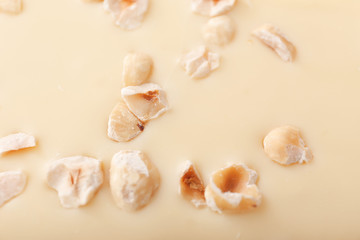 Sweet white chocolate with nuts as background, closeup