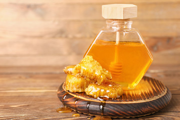 Jar of sweet honey on wooden background