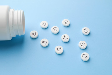 Pills with drawn faces on color background