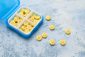 Box and pills with drawn faces on color background