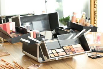 Case of professional makeup artist with decorative cosmetics on table