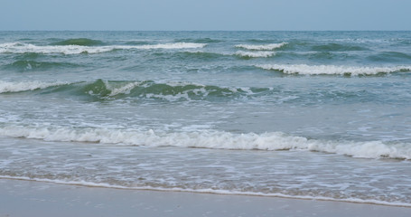 Waves break on tropical sand beach