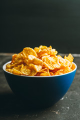 Tasty crispy corn flakes in bowl on the rustic background. Selective focus. Shallow depth of field.