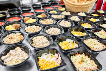 Food delivery. Different in plastic disposable lunch box with healthy natural food. Chicken broth, mashed soup, mashed potatoes with cutlet, seafood pasta, salads, pilaf with a fresh bun.