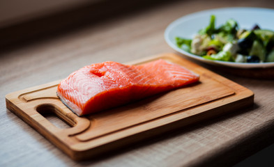 coocking at home a piece of fresh salmon on a wooden board in the morning, cooking a delicious breakfast