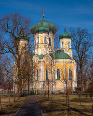 Pavlovsky Cathedral on a sunny spring day. The blue sky, green domes and the yellow walls of the cathedral. Gatchina, Russia