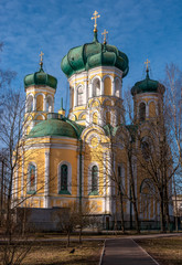 Pavlovsky Cathedral on a sunny spring day. The blue sky, green domes and the yellow walls of the cathedral. Gatchina, Russia