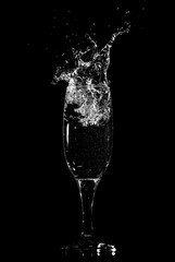 Splashes and drops of water in a glass are isolated on a black .