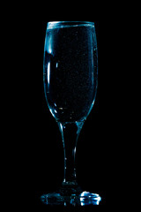 A glass of water is isolated on a black .