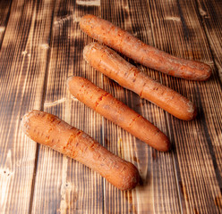 Boiled carrots lies on a wooden background.