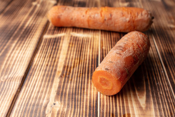Boiled carrots lies on a wooden background.