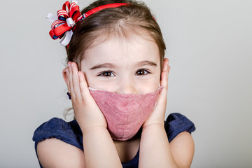 Little girl has fabric mask protect herself from Coronavirus COVID-19