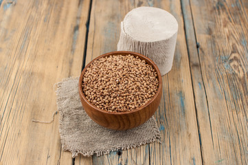 Toilet paper roll and a buckwheat on wooden background