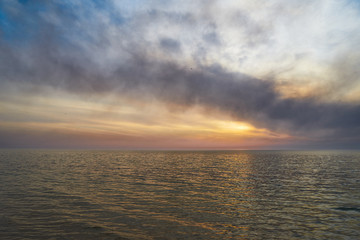 Sea sunset. Smoke wildfires sweeping across the sky.