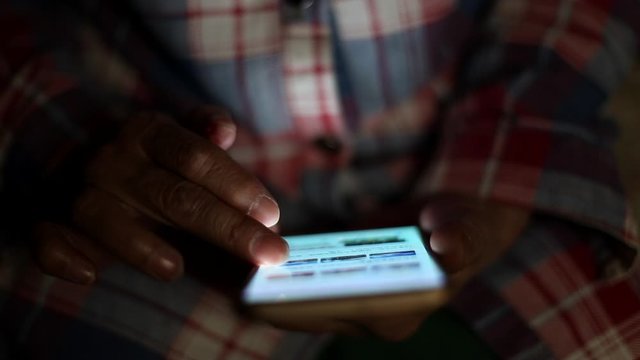 Close up of Chinese woman browsing web pages in her mobile phone at home