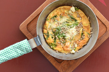 English breakfast - fried egg, beans, tomatoes, mushrooms, seeds served in a pan over rustic wooden board.