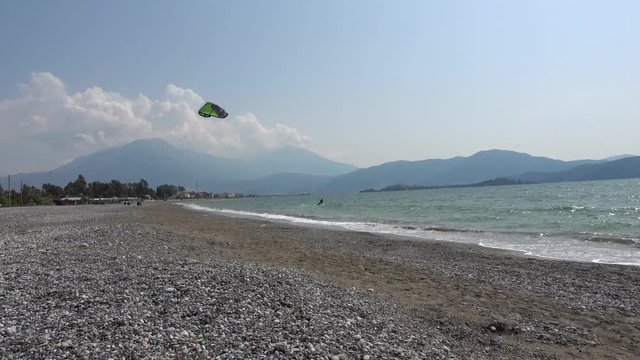 Fethiye, Turkey - 27th of Martch 2020: 4K Kitesurfing sportsman turns his kite and rides back passing in front of camera
