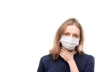 Sick young blond woman in protective mask touching her throat in isolation