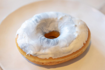 Delicious donuts with a filling and blue glaze on dish. 