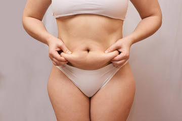 Fat unhealthy woman body. Pinch belly side. Measurement lady procedure. Medicine pinching. Anti...