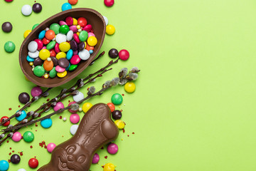 Easter Background. Festive Chocolate Egg and Rabbit. Colorful Ester Sweet Food. Copy SPace, Top View