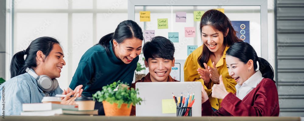 Aufkleber Asian ux developer and ui designer looking at laptop screen for successful design approved at modern office.Creative digital development agency