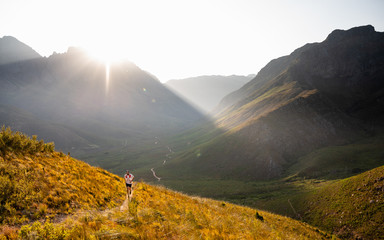 A single trail runner running up a steep mountain trail at sunrise - 334371177