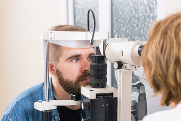 Medicine, health, ophthalmology concept - patient checks her vision by an ophthalmologist.
