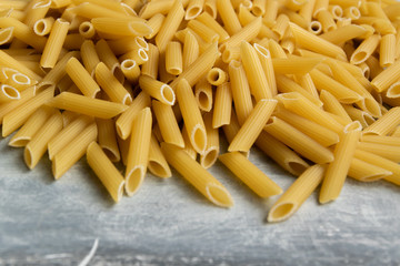 Food background -  dry penne pasta, whole wheat uncooked ingredient