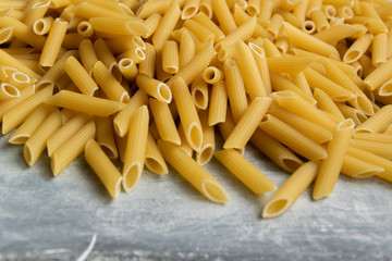 Food background -  dry penne pasta, whole wheat uncooked ingredient
