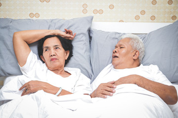 Asian elderly couples Sleeping in bed in the bedroom Men snoring so loudly that women can't sleep....