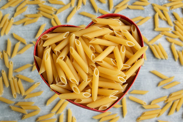 Food background -  dry penne pasta, whole wheat uncooked ingredient