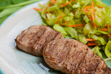 Grilled juicy steak with vegetable salad and herbs. Concept for a tasty and healthy meal.