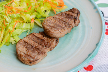 Grilled juicy steak with vegetable salad and herbs. Concept for a tasty and healthy meal.