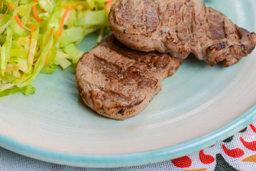 Grilled juicy steak with vegetable salad and herbs. Concept for a tasty and healthy meal.