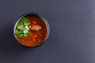 Traditional Ukrainian beetroot soup - borscht or borshch with meat and fresh parsley over black background. Copy space.