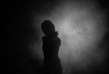 Female silhouette in shadow and smoke