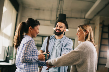 Business people putting their hands together.