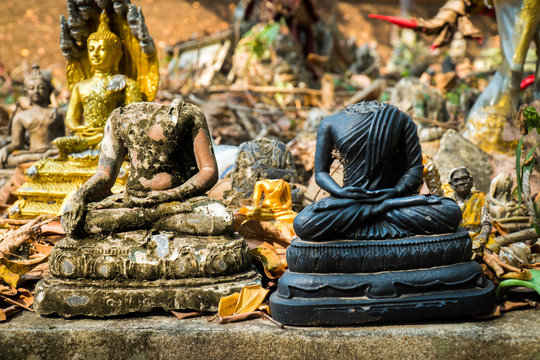 Two headless buddha image statue outdoor at the temple in thailand. Closeup damaged buddha image sculpture background