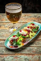 Cold light beer in glass and italian bruschetta on gray background. Beer with foam. place under the text