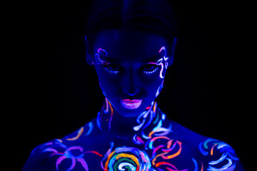 serious caucasian woman with fluorescent prints on skin, attractive model confidently look at...