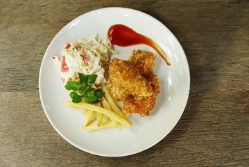 Fried chicken and french fries with vegetables salad from top view prepare for serving in the kitchen , home made food image for background , selective  focus .