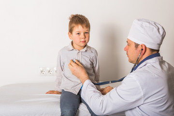 Obraz premium Man doctor and child patient. Male pediatrician with stethoscope listening to lung and heart sound of little boy